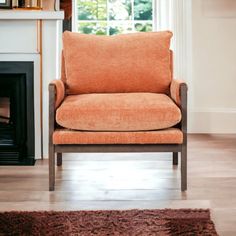 an orange chair sitting in front of a fireplace with a rug on the floor next to it