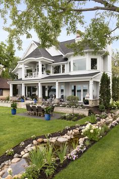 a large white house sitting on top of a lush green field