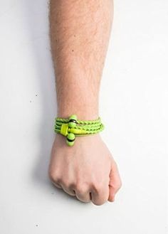 a man's arm with a green bracelet on it