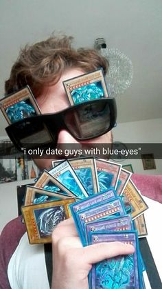 a man holding up some cards with the caption'i only date guys with blue - eyes '