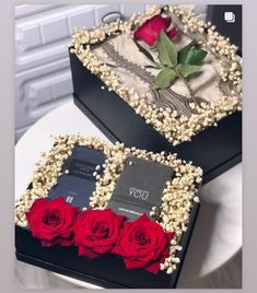 two black boxes with red roses in them