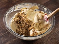 a bowl filled with cream and spices on top of a wooden table