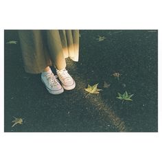 a person standing on the ground with their feet up in front of leaves and grass