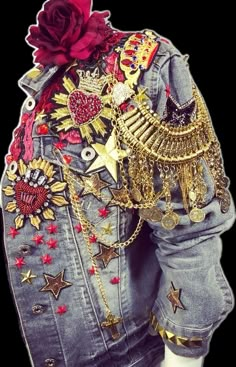 a woman's denim jacket with gold and red decorations on it