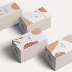 three boxes with different designs on them sitting next to each other in front of a white background