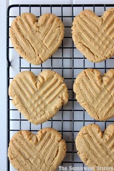 four peanut butter cookies cooling on a wire rack