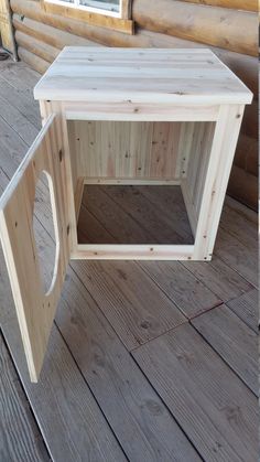 a small wooden table sitting on top of a wooden floor next to a log cabin