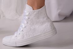 a close up of a person's white shoes with lace on the top and bottom