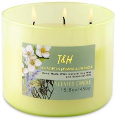 a yellow scented candle with white flowers on the label that says, t & h