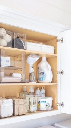 an organized kitchen cabinet filled with cleaning products