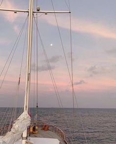 there is a sailboat that is sailing in the ocean at sunset or sunrise time