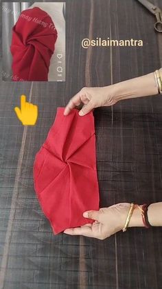 a woman is cutting out an origami piece with scissors and fabric on the table