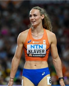 a female athlete in an orange top and blue shorts