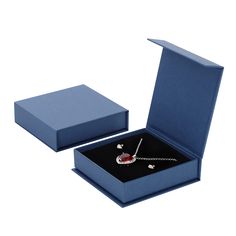 an open blue box with a necklace in it and a red object on the inside