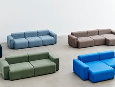 four different colored couches sitting next to each other on the floor in front of a white wall