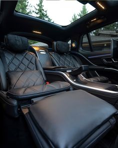 the interior of a car with black leather seats and an ottoman in front of it