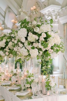 the centerpieces are filled with white flowers and greenery