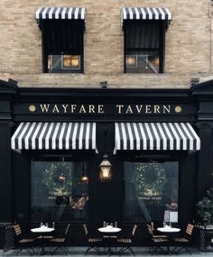 the outside of a restaurant with black and white awnings on it's windows