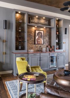 a living room filled with furniture and a painting on the wall above it's bar