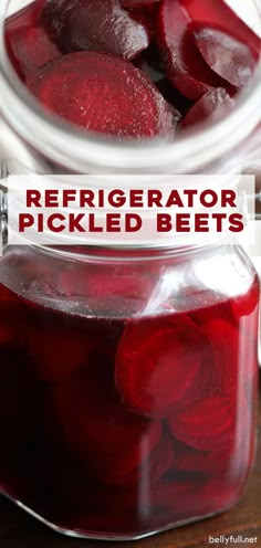 a jar filled with pickled beets sitting on top of a wooden table next to another jar