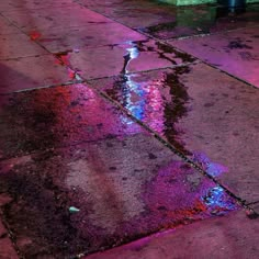 a wet sidewalk with puddles of water on it