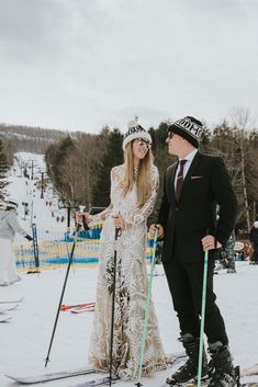 a man and woman standing next to each other on ski's in the snow