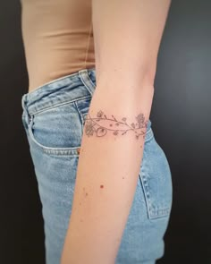 a woman's arm with a flower tattoo on the left side of her right arm