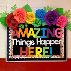 there is a sign that says amazing things happen here with flowers and leaves on it