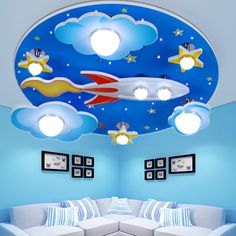 a living room with blue walls and white couches on the floor, painted like a rocket ship