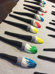 there are many different colored brushes lined up on the table