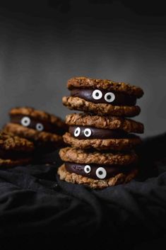 cookies with eyes and googly eyes are stacked on top of each other in front of a black background