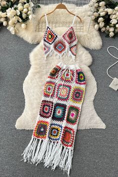 two pieces of crocheted clothing sitting on top of a rug