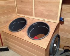 two buckets on top of a washer in a room with wood paneling