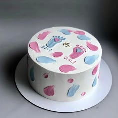 a white cake with pink and blue designs on it