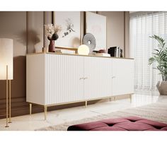 a living room with a large white cabinet next to a lamp and pictures on the wall