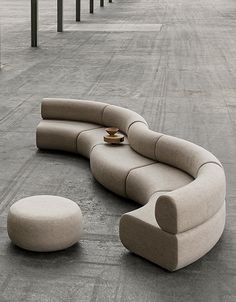 a curved couch and ottoman in an empty parking lot