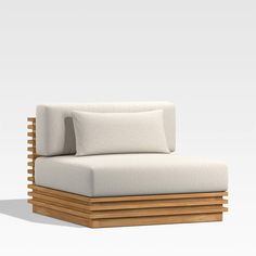 a white couch with pillows sitting on it's back and side ends, in front of a gray background