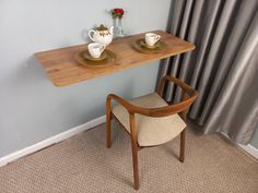 a table with two tea cups on it next to a chair