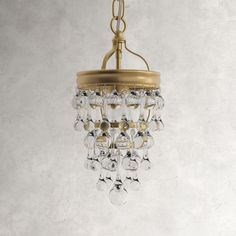 a chandelier hanging from the ceiling with clear glass drops on it's sides