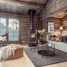 a living room filled with furniture and a fire place in the middle of a wooden wall