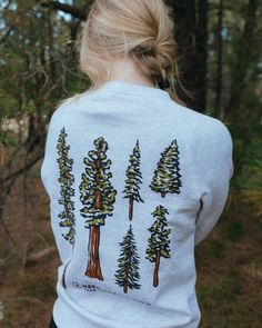 This pullover is an ode to the quiet giants of the forest. Trees’ canopies provide shade & protection - and they also happen to be some of the best eye candy around! The wild just wouldn't be the same without them. Slow down and take time to notice conifers in this comfy pullover. Regular fit (size up for a more relaxed fit) Midweight Ultra comfy anti-pilling fleece (80% Cotton/ 20% Poly blend) Preshrunk to minimize shrinkage We’re not your average outdoor brand... together we pick up one pound Mountain Sweatshirt Design, Nature Streetwear, Forest Trees, One Pound, Nature Study, Just Peachy, Fragrance Gift Set, Ring Pendant Necklace, The Quiet