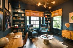 a living room filled with furniture and bookshelves next to a wooden table in front of a window