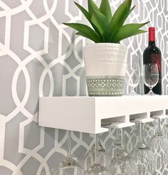 a shelf with wine glasses and a potted plant