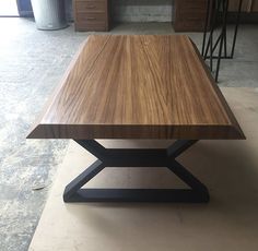 a wooden table sitting on top of a floor next to other desks and drawers