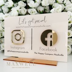 two gold toned facebook logo earrings are displayed in front of some white flowers with the caption let's get social