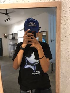 a person taking a selfie in front of a mirror while wearing a blue hat