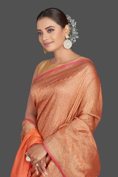 Be a vision of elegance on wedding occasions in this gorgeous orange color tussar Banarasi saree! The saree has a beautiful overall zari work which makes oh-so-striking! It comes with a pink blouse piece. Shop Banarasi sarees in USA from Pure Elegance. Disclaimer: The shown stitched blouse on the model is for display purpose only. The saree comes with a matching blouse piece and finished with fall and piko. The actual product may vary slightly from the image. These are custom orders, hence expect slight variation in color, placement of the motif or buta. ESTIMATED DELIVERYBecause this is a custom order, it would take about 4 weeks from the date of purchase. RETURN POLICYThis product is a custom order and cannot be returned or exchanged. Orange Tussar Silk Traditional Wear For Diwali, Orange Raw Silk Saree, Orange Bollywood Slub Silk Traditional Wear, Orange Slub Silk Bollywood Traditional Wear, Orange Tussar Silk Traditional Wear, Orange Tussar Silk Saree For Festive Occasion, Orange Tussar Silk Festive Saree, Orange Tussar Silk Traditional Drape, Festive Orange Tussar Silk Saree