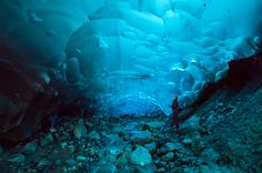 a man is standing in an ice cave