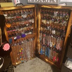 an open wooden case filled with lots of earring and necklaces on display in a store