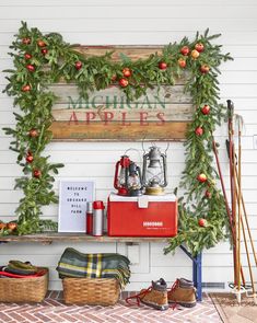 a christmas display on the side of a white building with evergreen garland and red accents